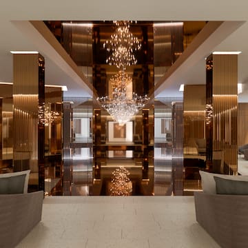 a lobby with chandelier and chairs