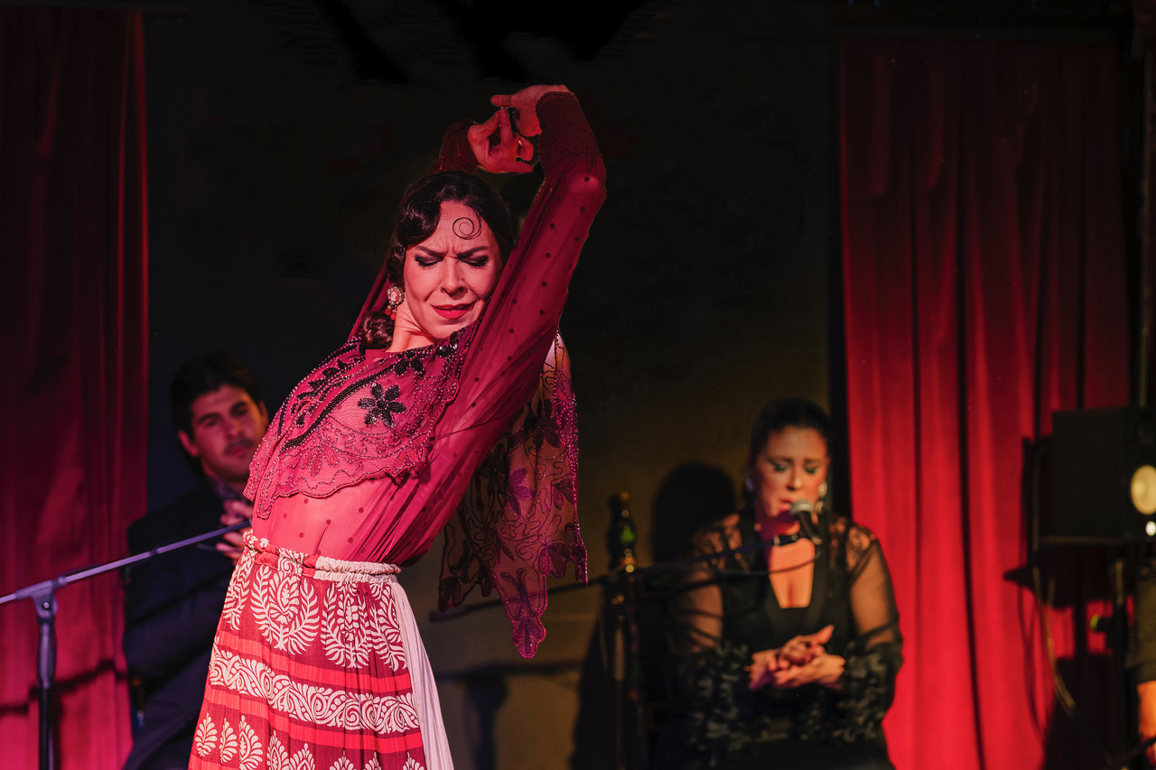 a woman in a red dress with a man in a microphone and a woman in a red dress