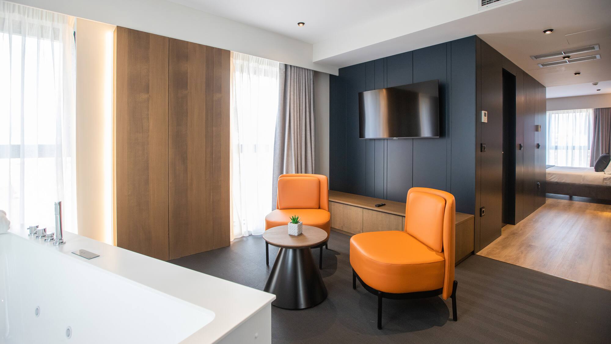 a room with orange chairs and a tv