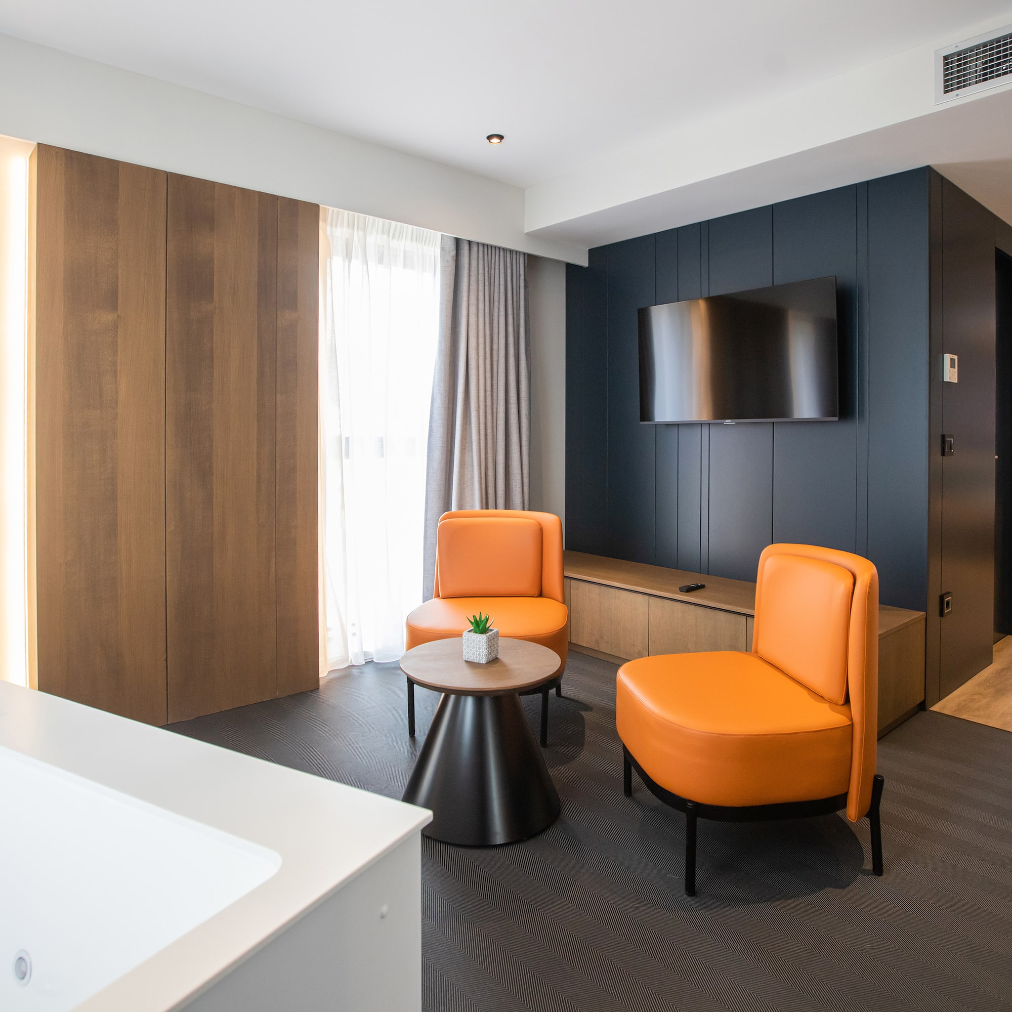 a room with orange chairs and a tv