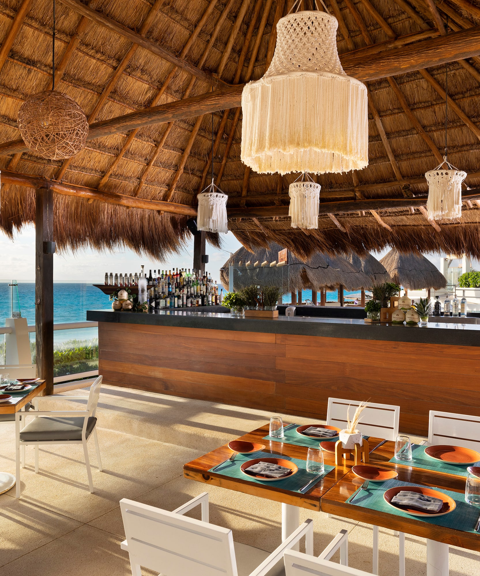 a restaurant with a thatched roof and a beach view