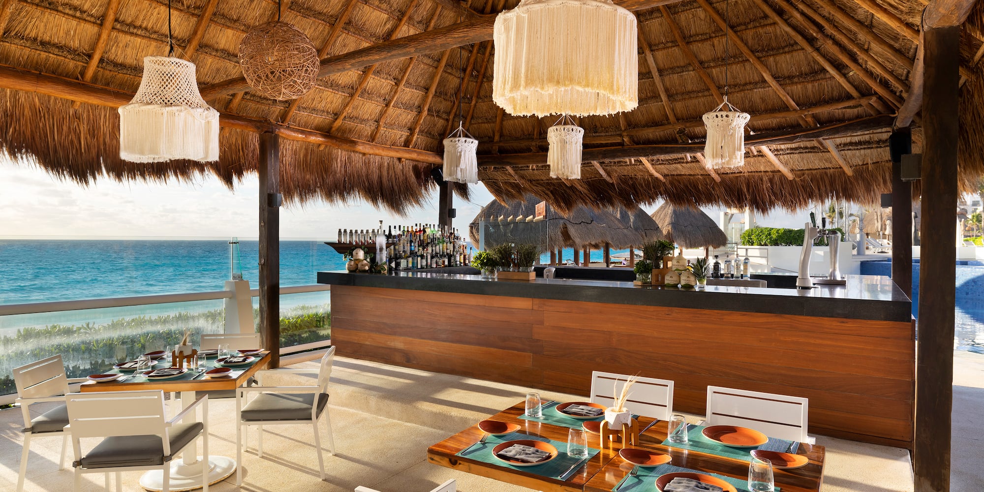 a restaurant with a thatched roof and a beach view