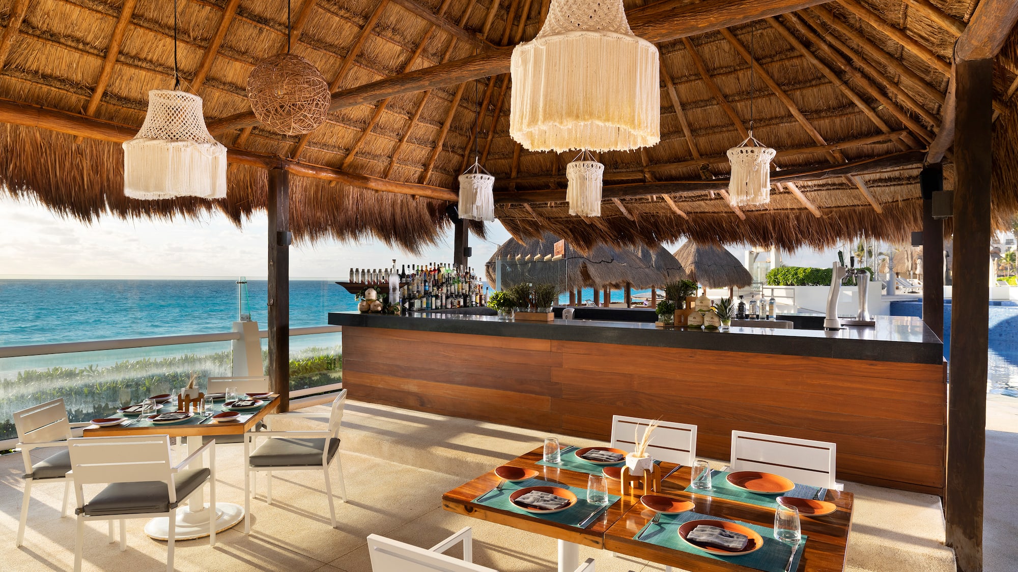 a restaurant with a thatched roof and a beach view