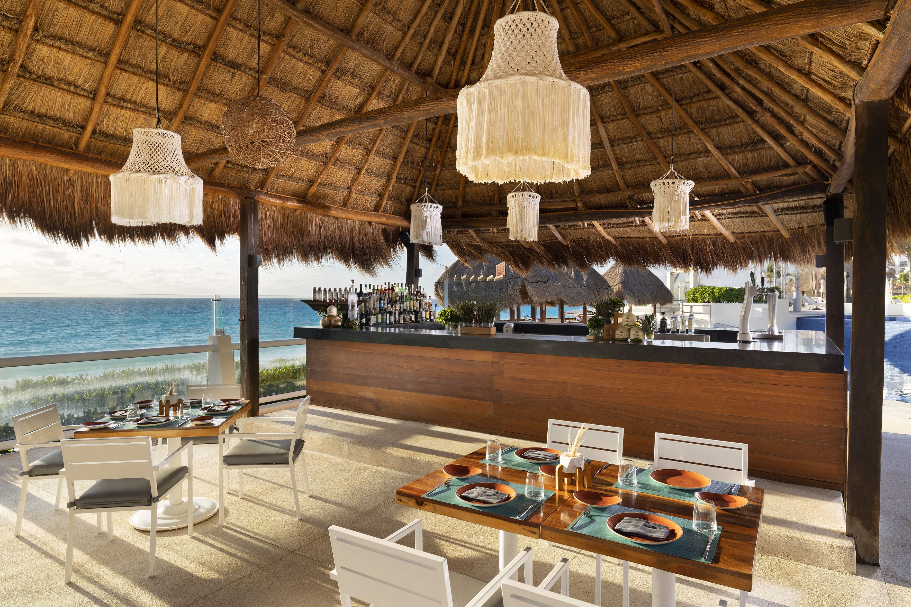 a restaurant with a thatched roof and a beach view