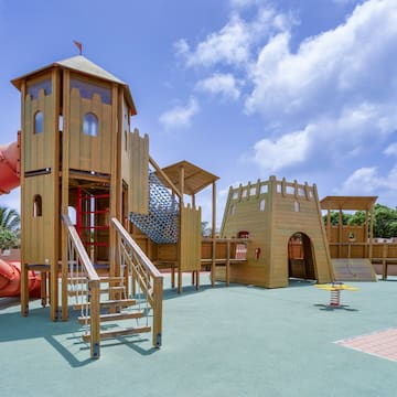 a playground with a slide and a red tube
