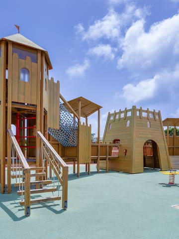 a playground with a slide and a red tube
