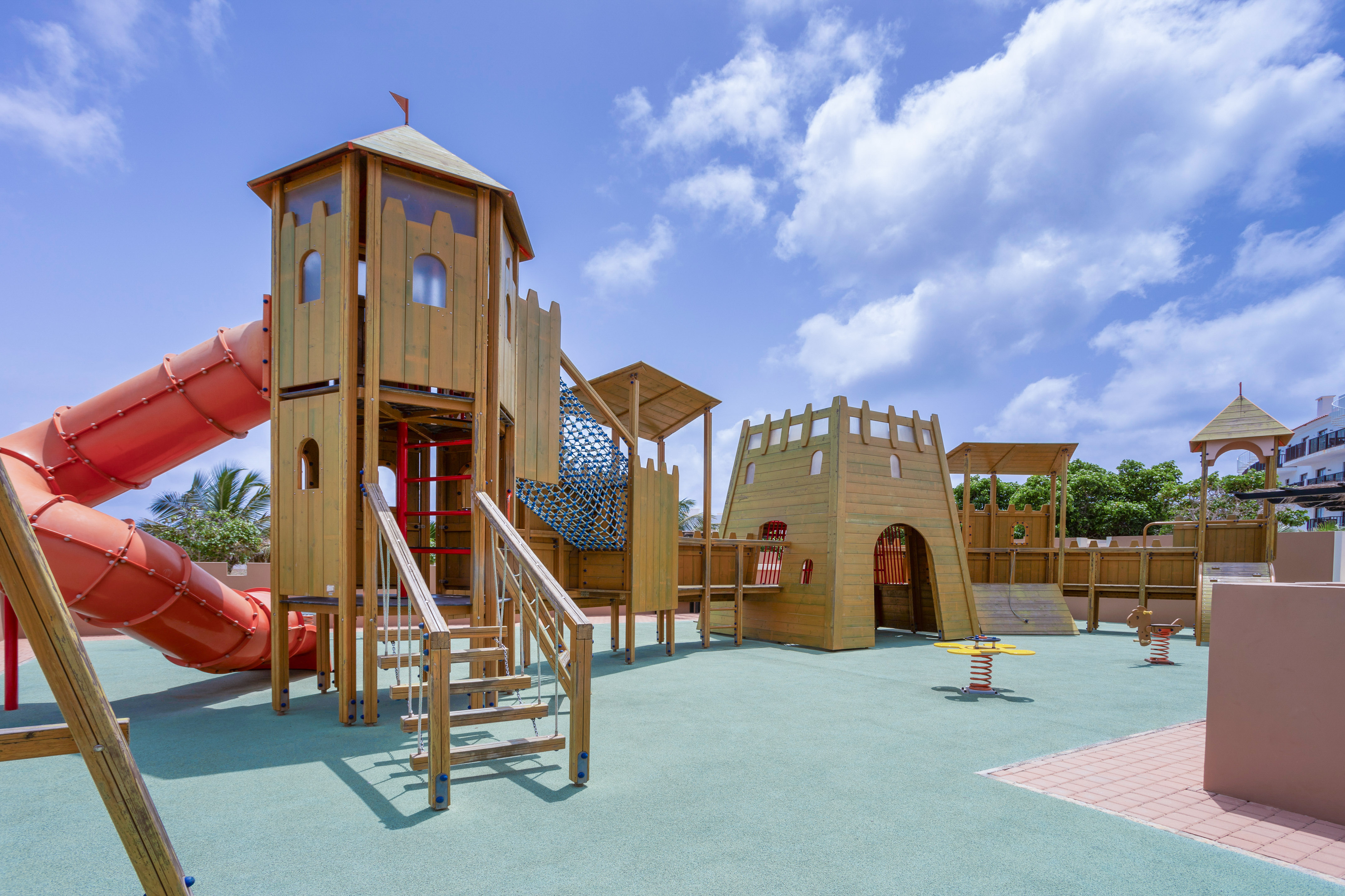 a playground with a slide and a red tube