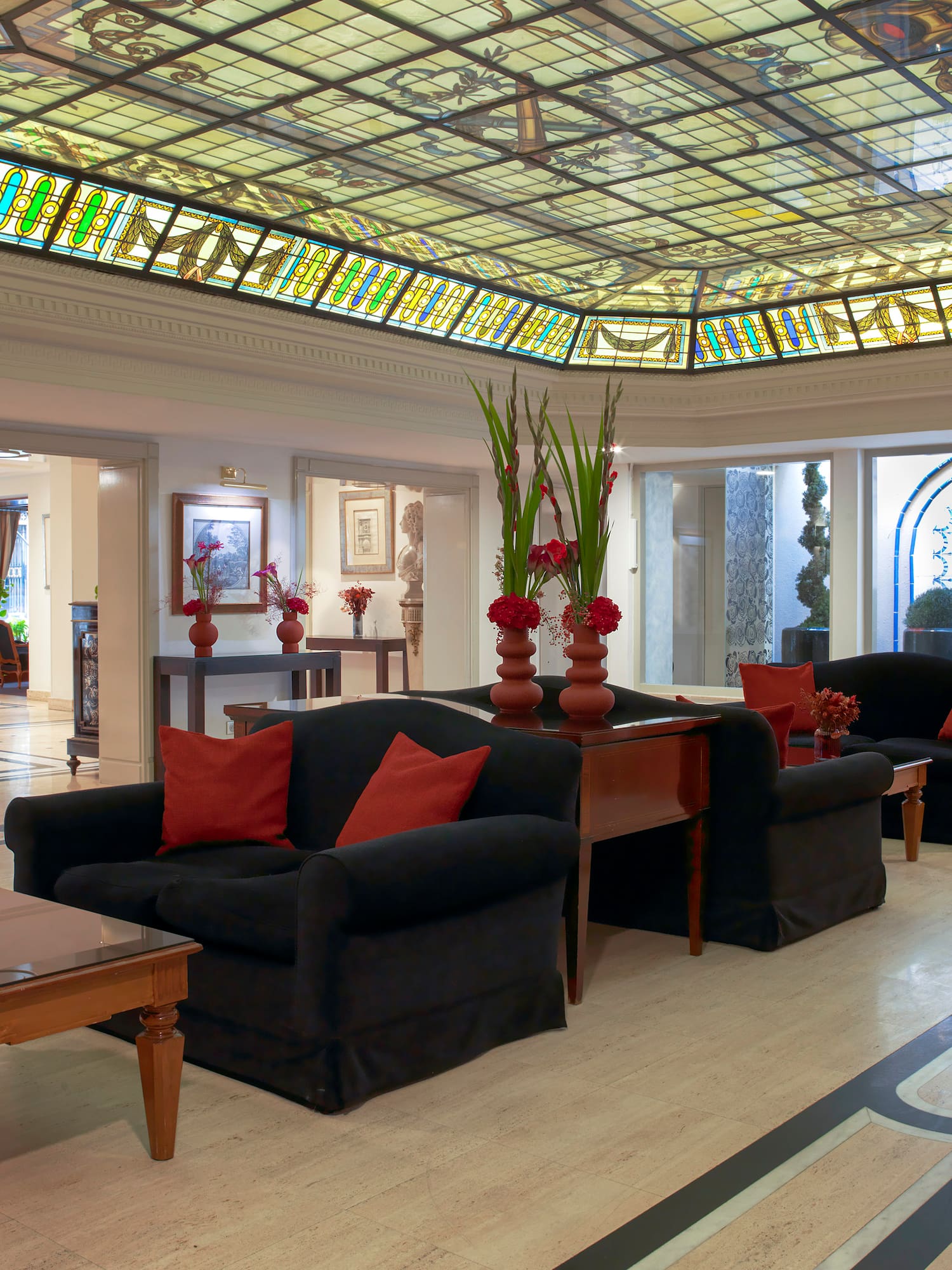 a room with a stained glass ceiling and a couch and chairs