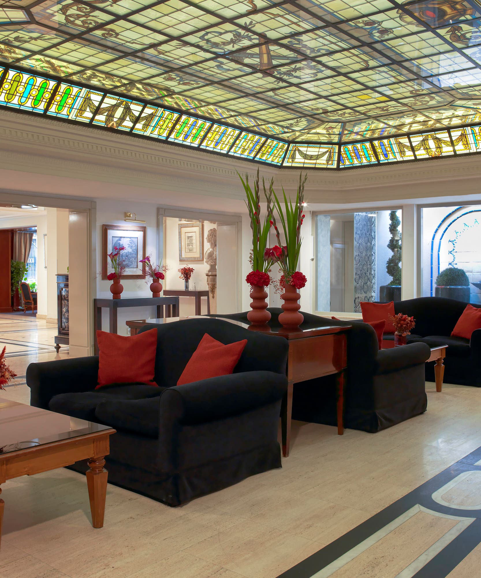 a room with a stained glass ceiling and a couch and chairs