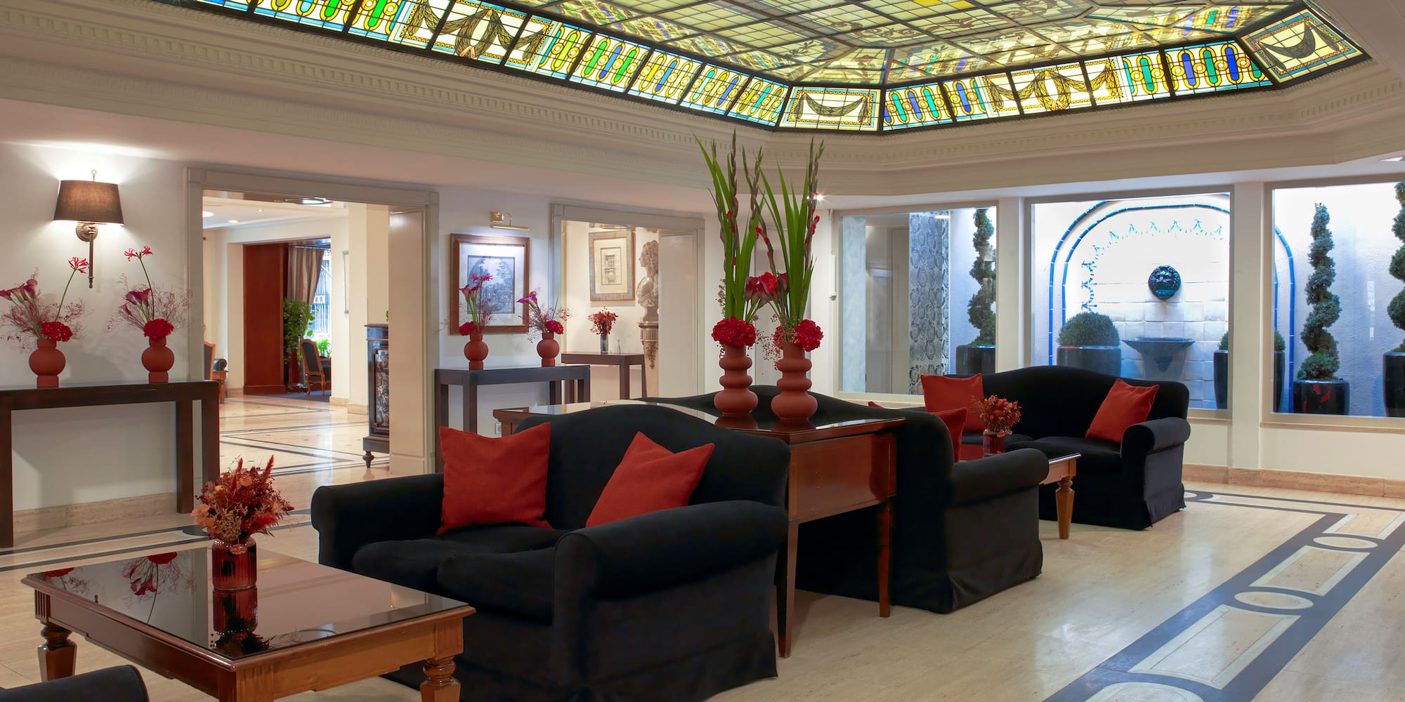 a room with a stained glass ceiling and a couch and chairs