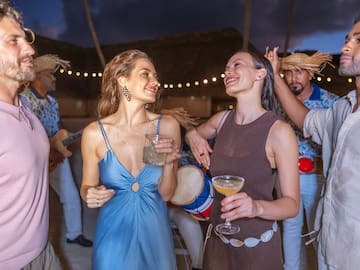 a group of people dancing and drinking