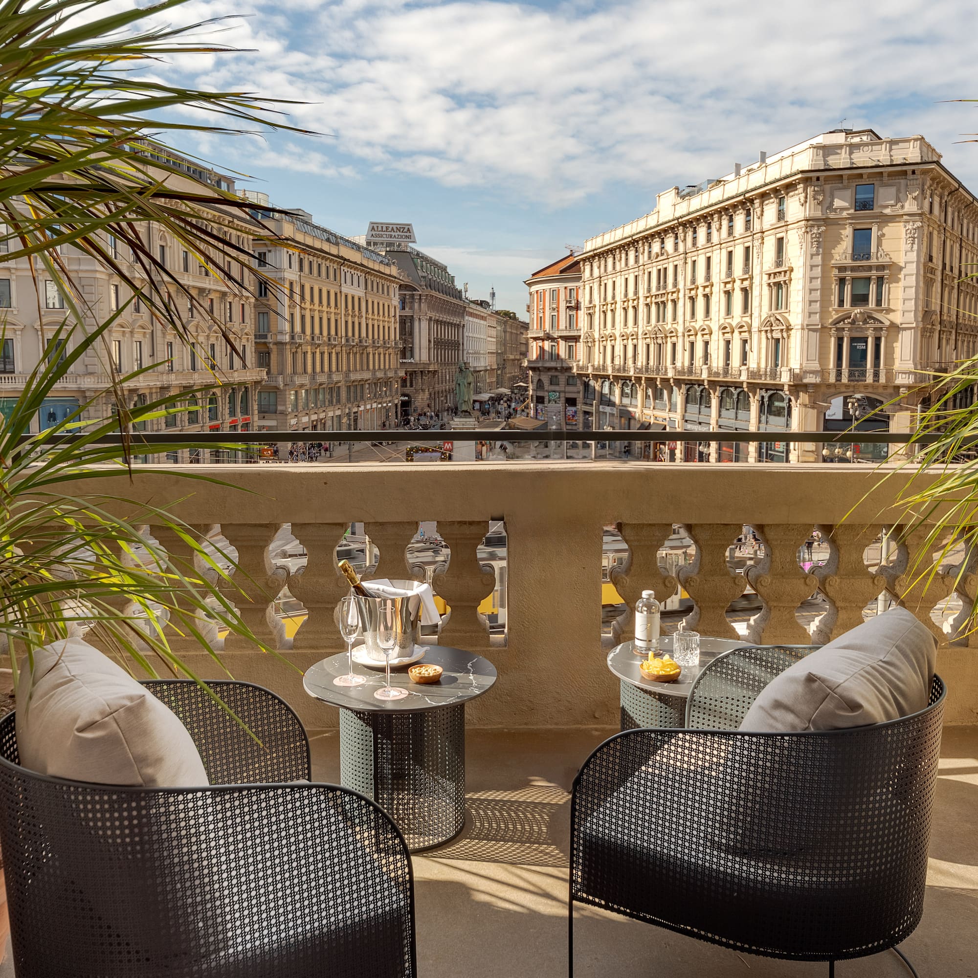 a table and chairs on a balcony with a view of a city