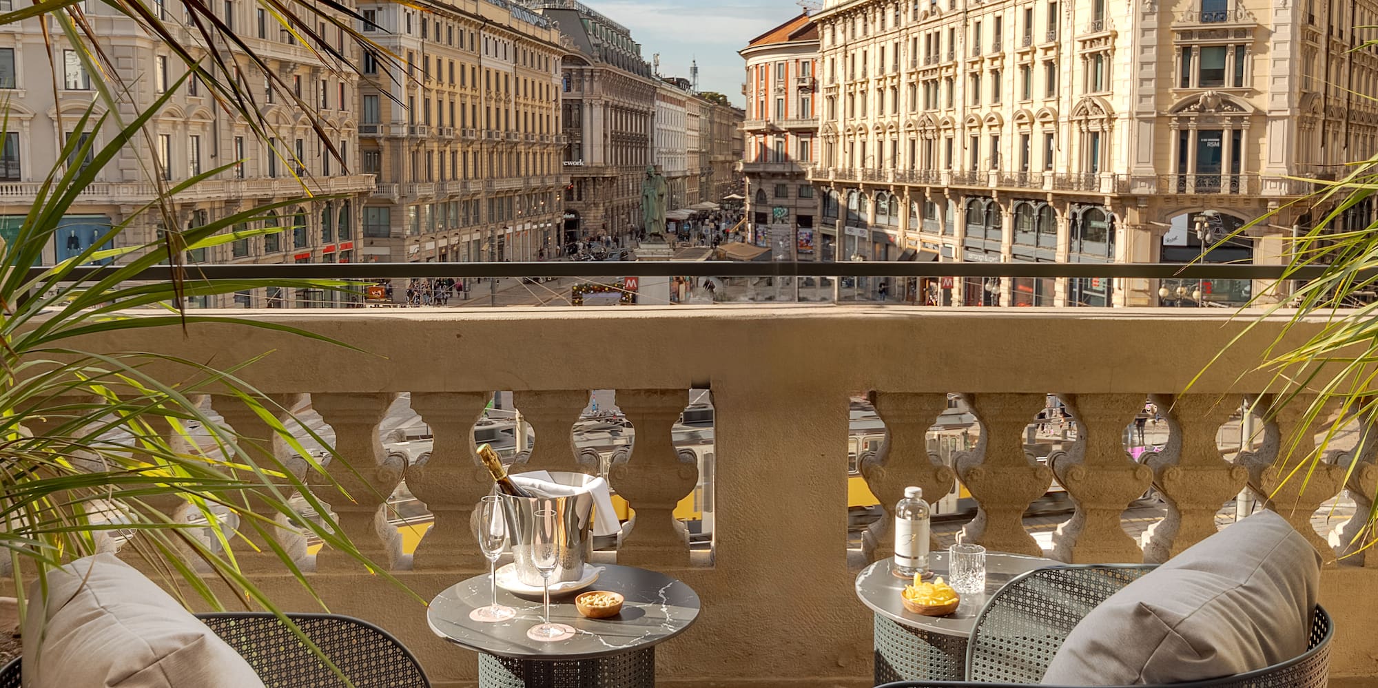 a table and chairs on a balcony with a view of a city