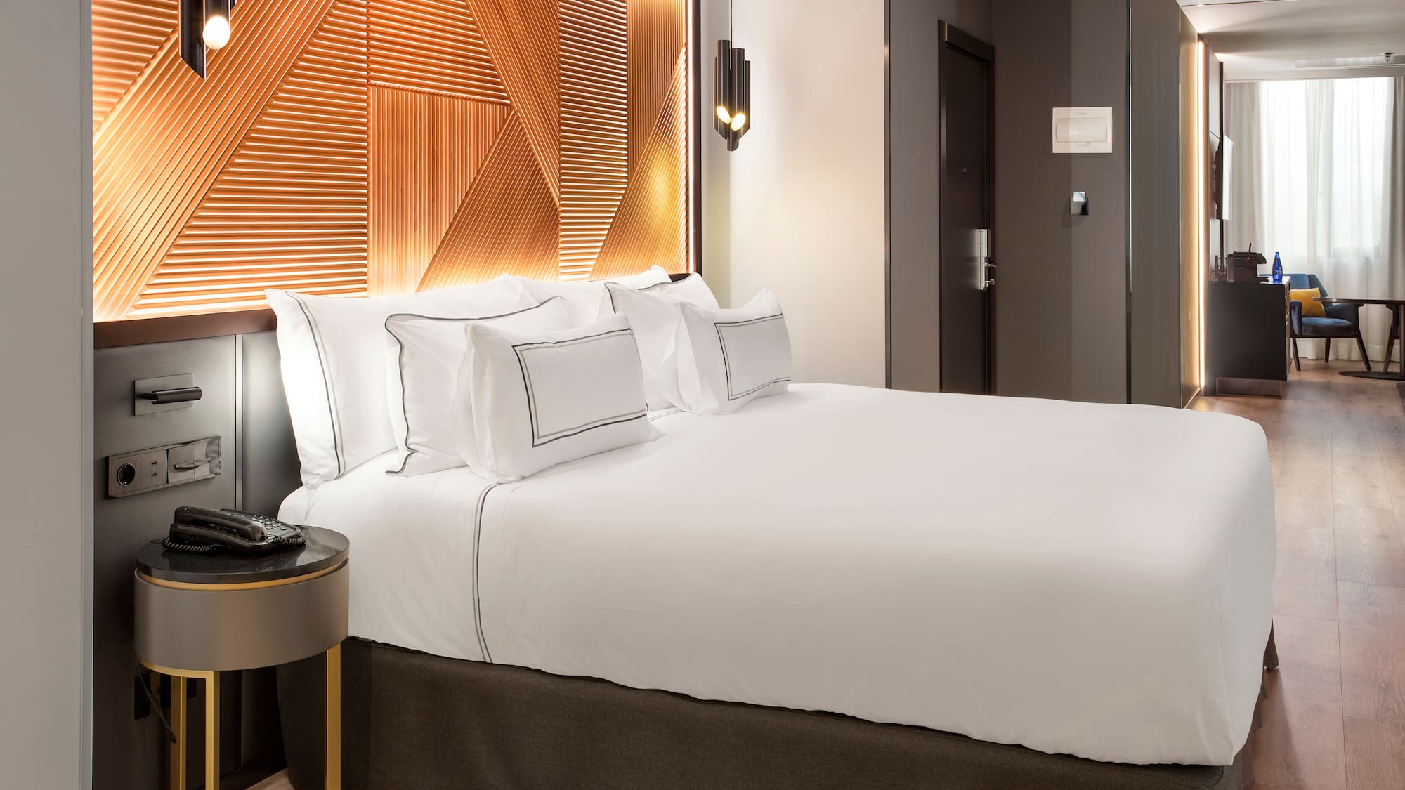 a bed with white sheets and a brown headboard