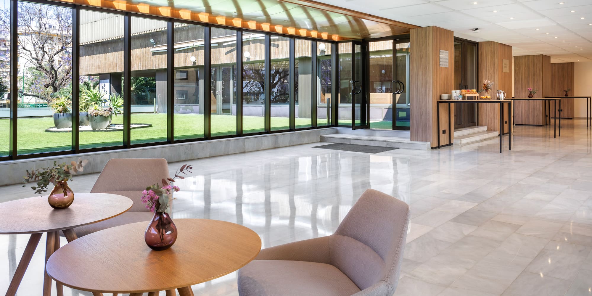 a room with a glass wall and a table and chairs