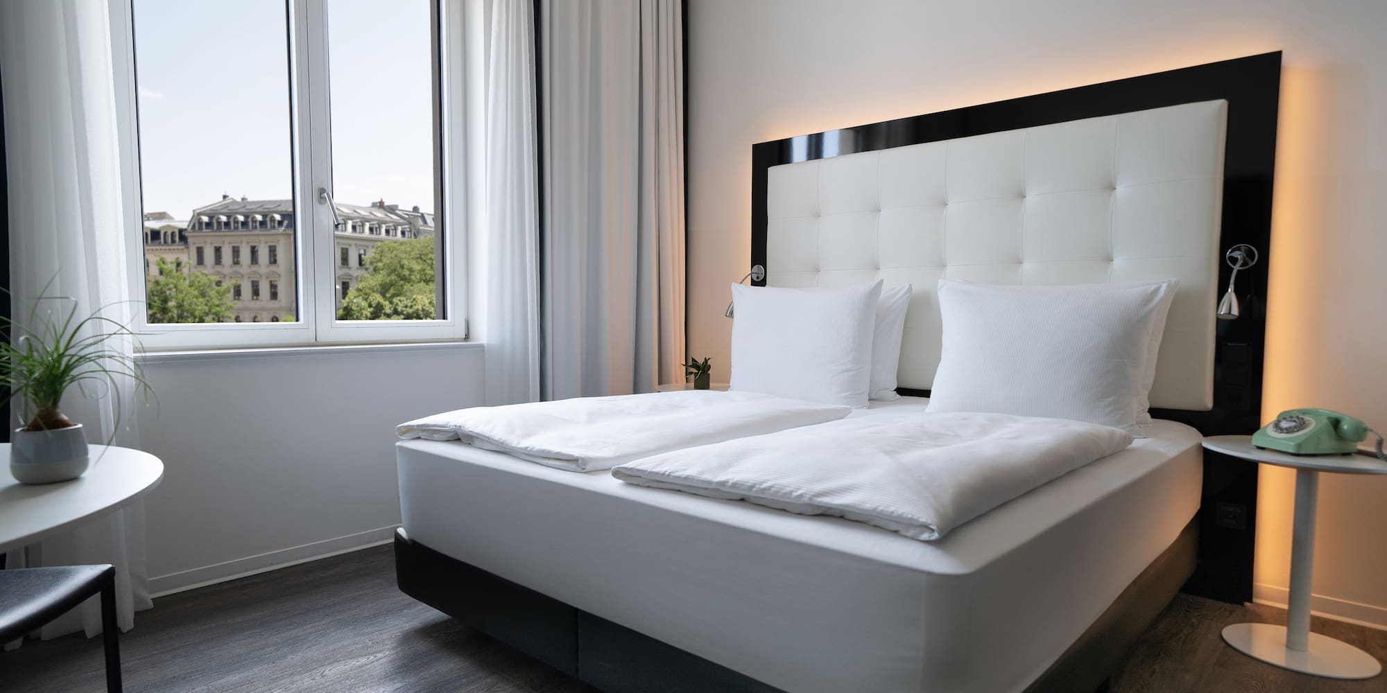 a bed with white sheets and pillows