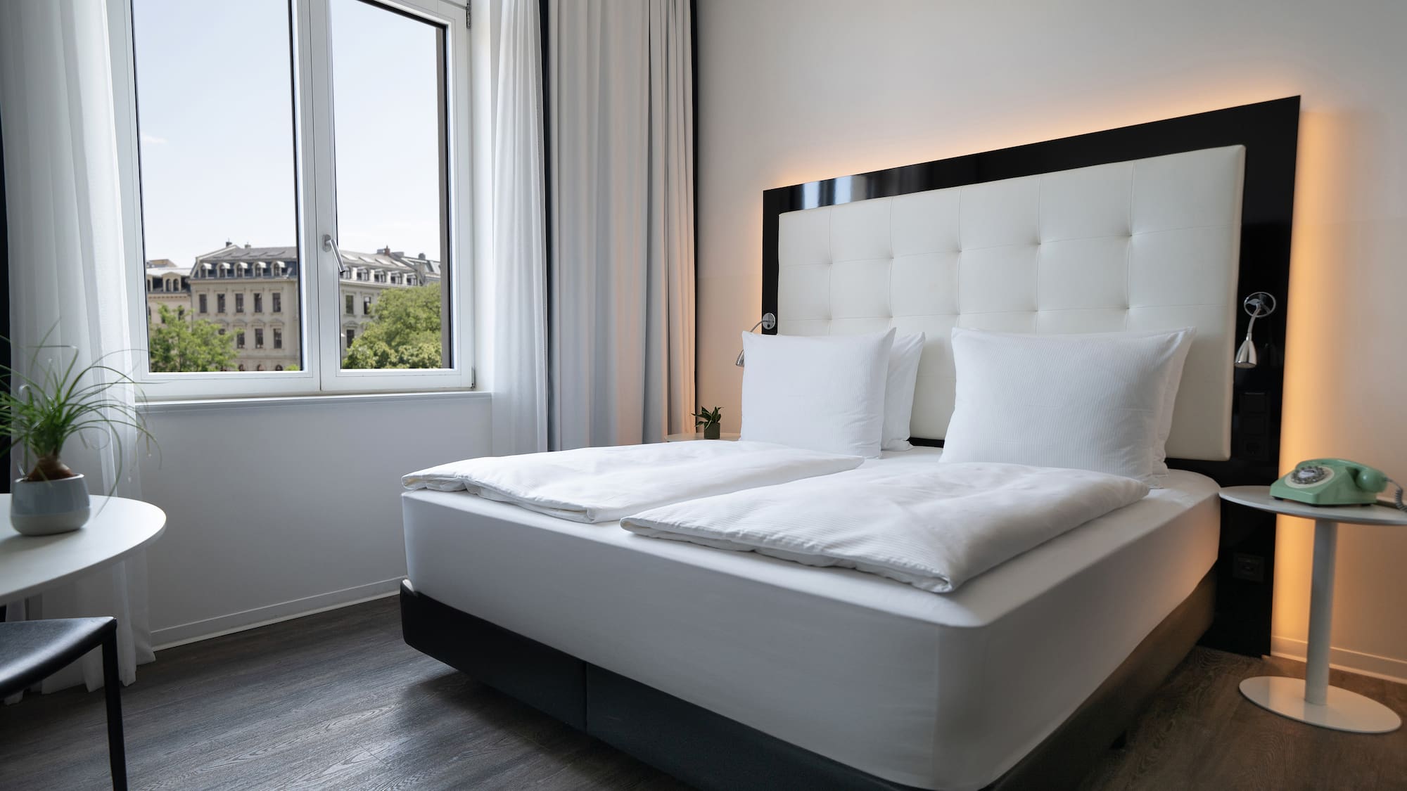 a bed with white sheets and pillows