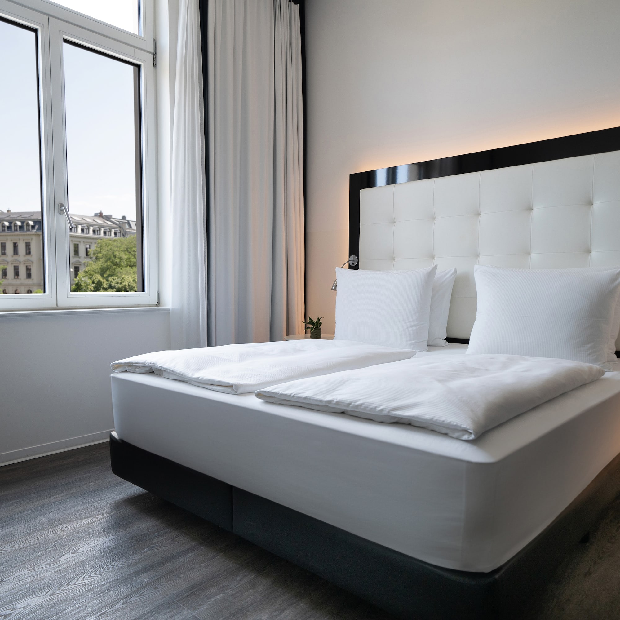 a bed with white sheets and pillows