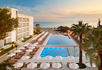 a pool with umbrellas and chairs and palm trees