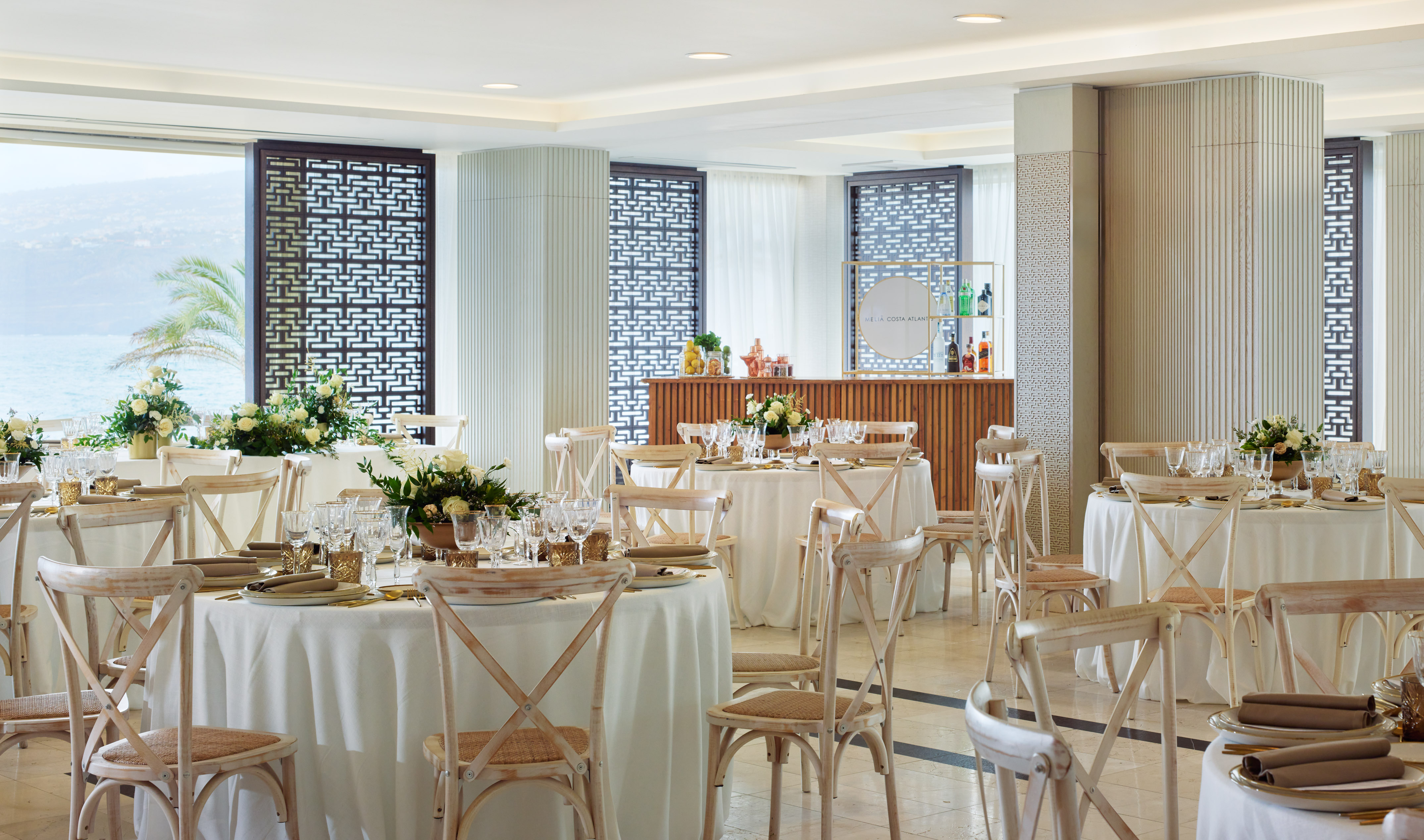 Meliá Costa Atlantic elegant event hall, set tables, floral decor, ocean view.