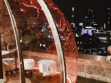 a glass dome with a table and chairs on a rooftop