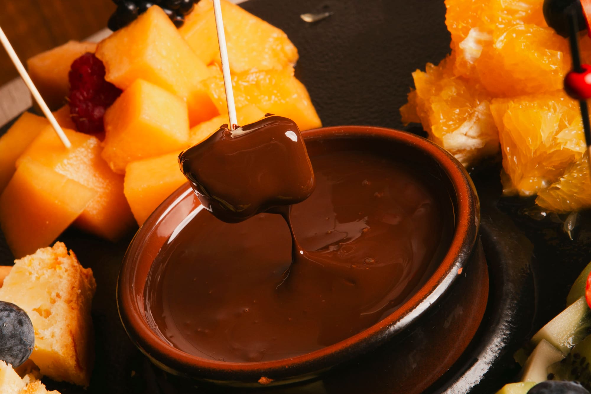 a chocolate fondue with fruit on a plate