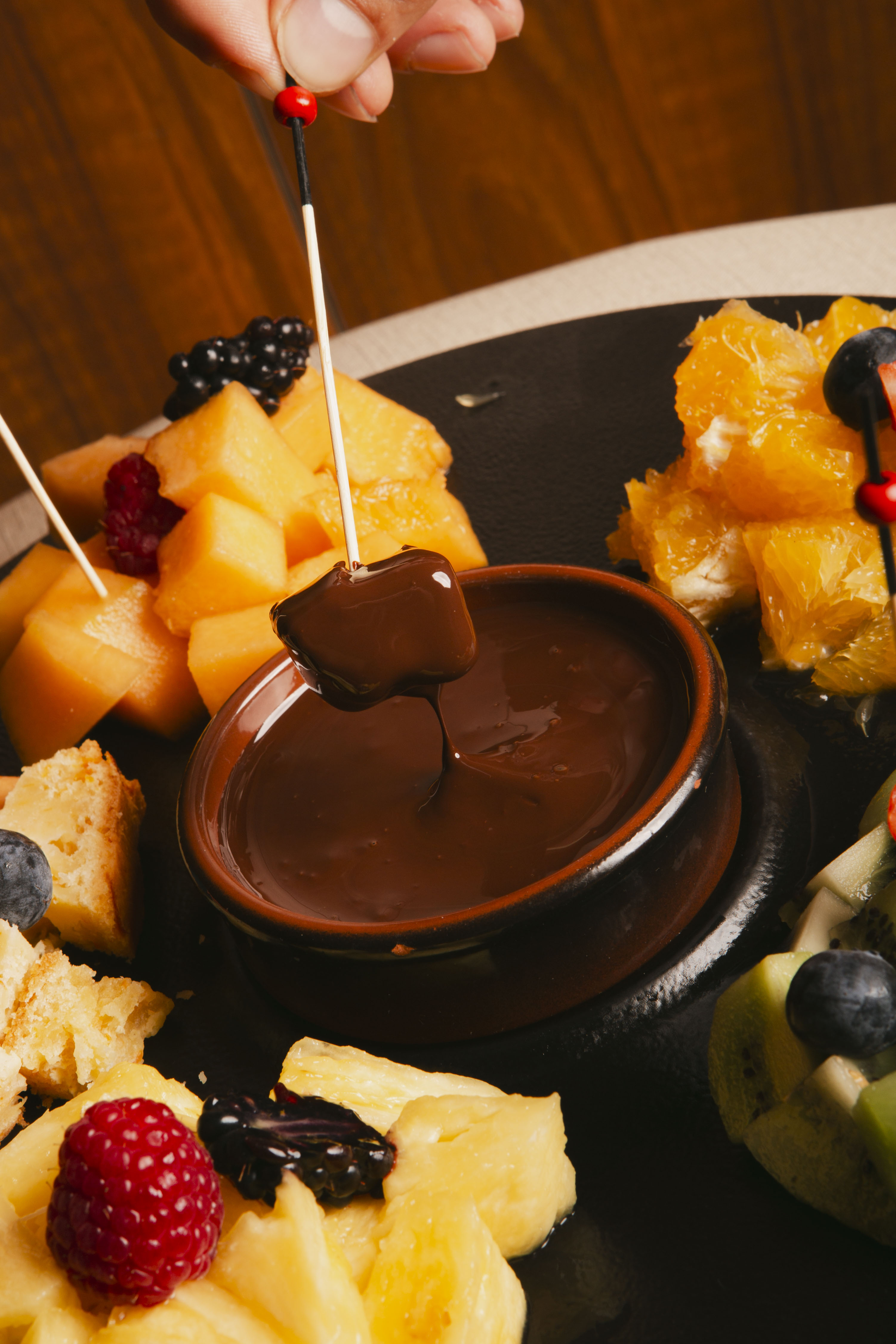 a chocolate fondue with fruit on a plate