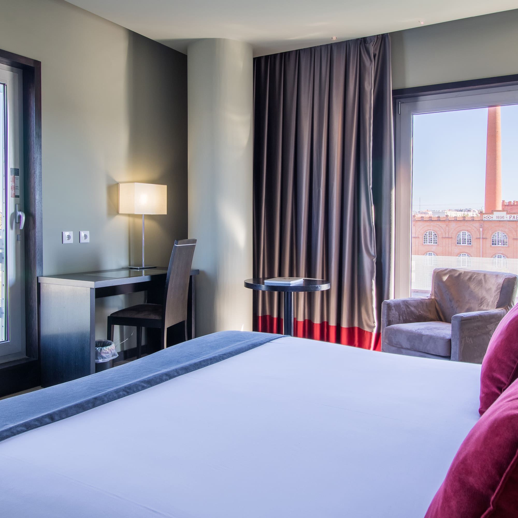 a room with a bed and a chair and a table