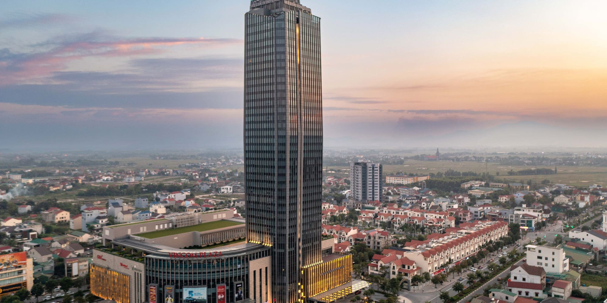 a tall building with many windows and a city in the background