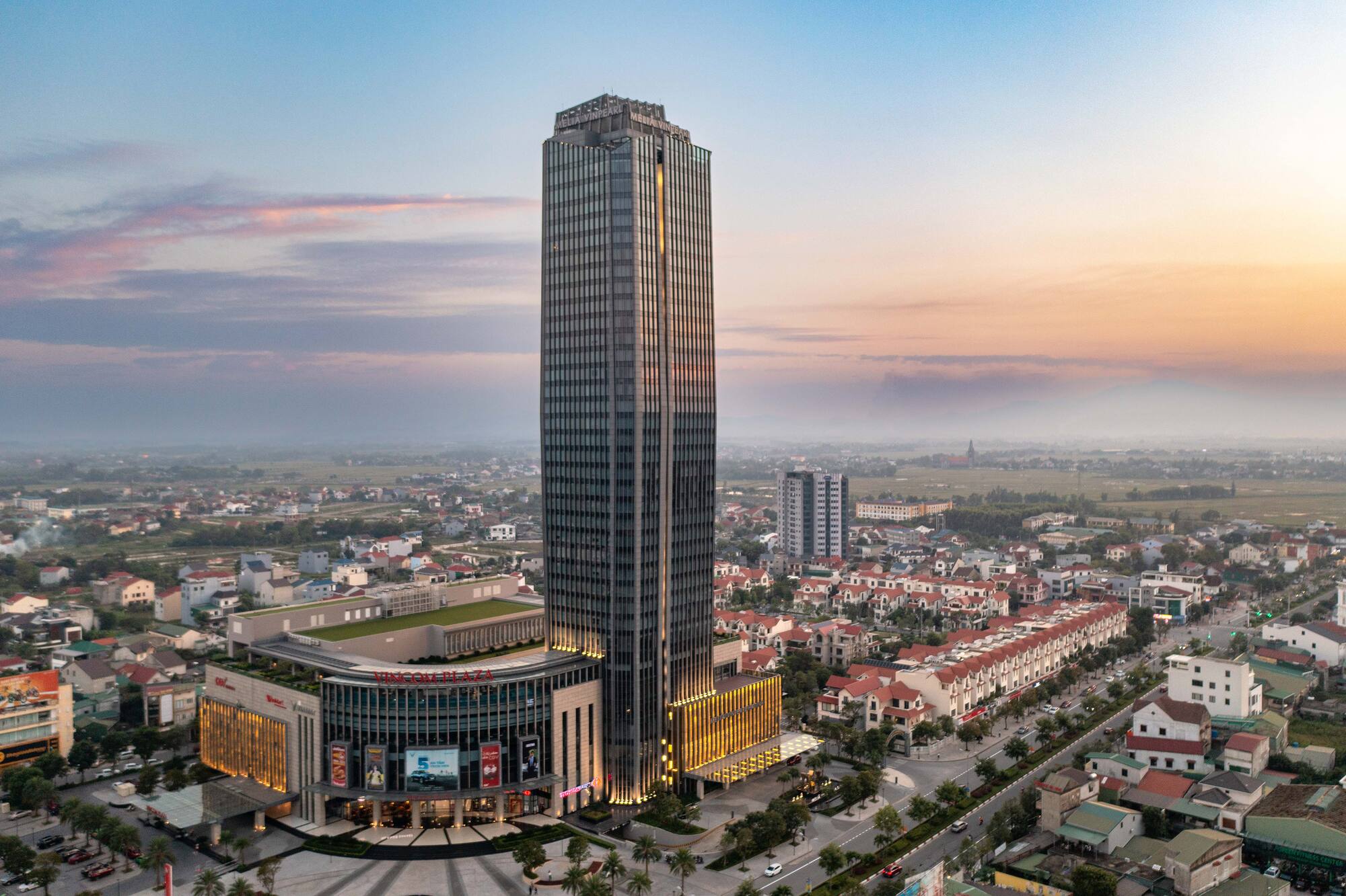 a tall building with many windows and a city in the background