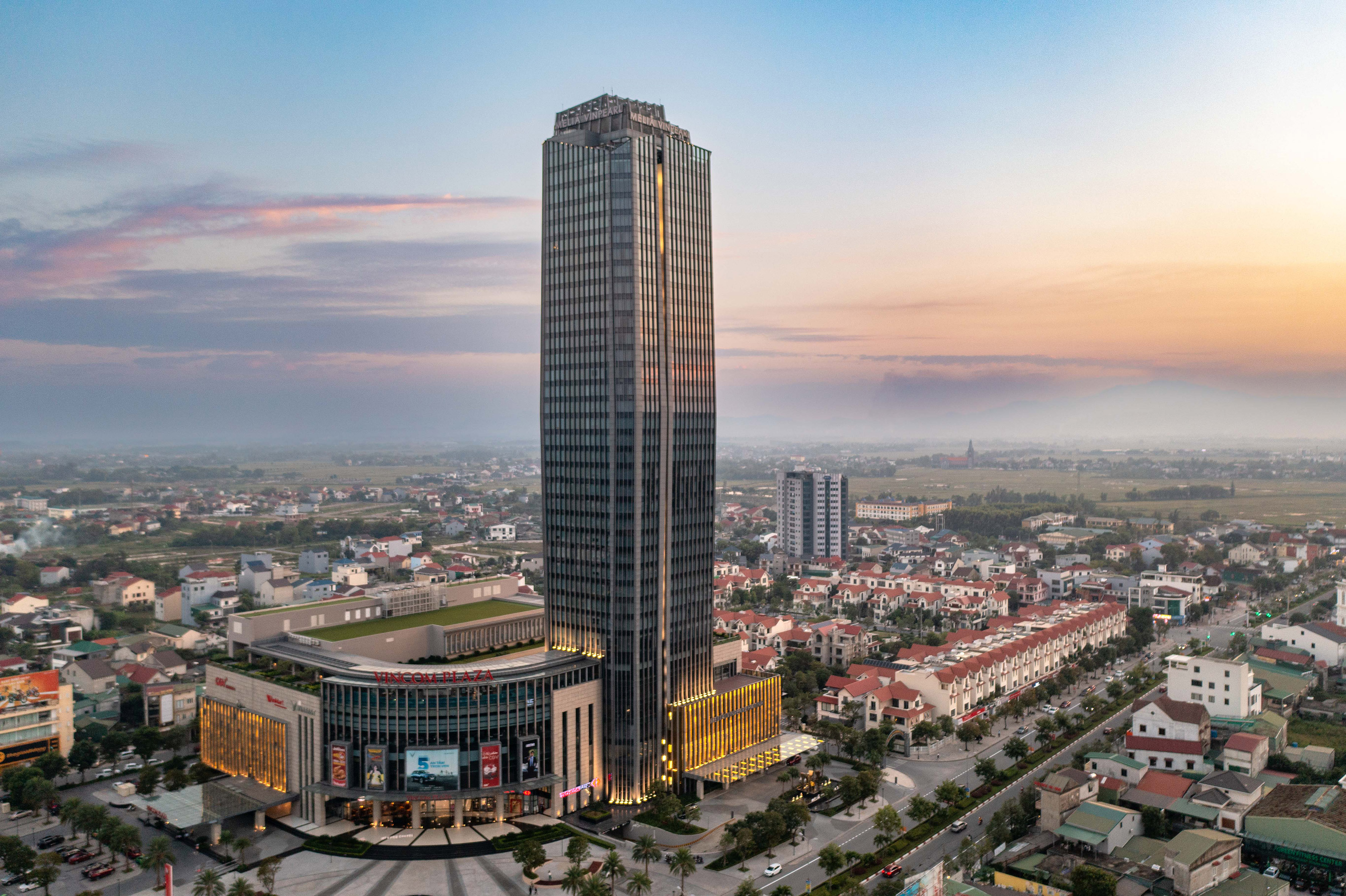 a tall building with many windows and a city in the background