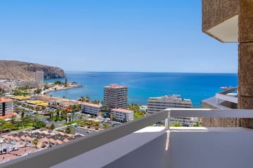 a balcony overlooking a city and the ocean
