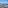 Panoramic balcony view of a sunny coastal town, blue ocean, and rugged cliffs.