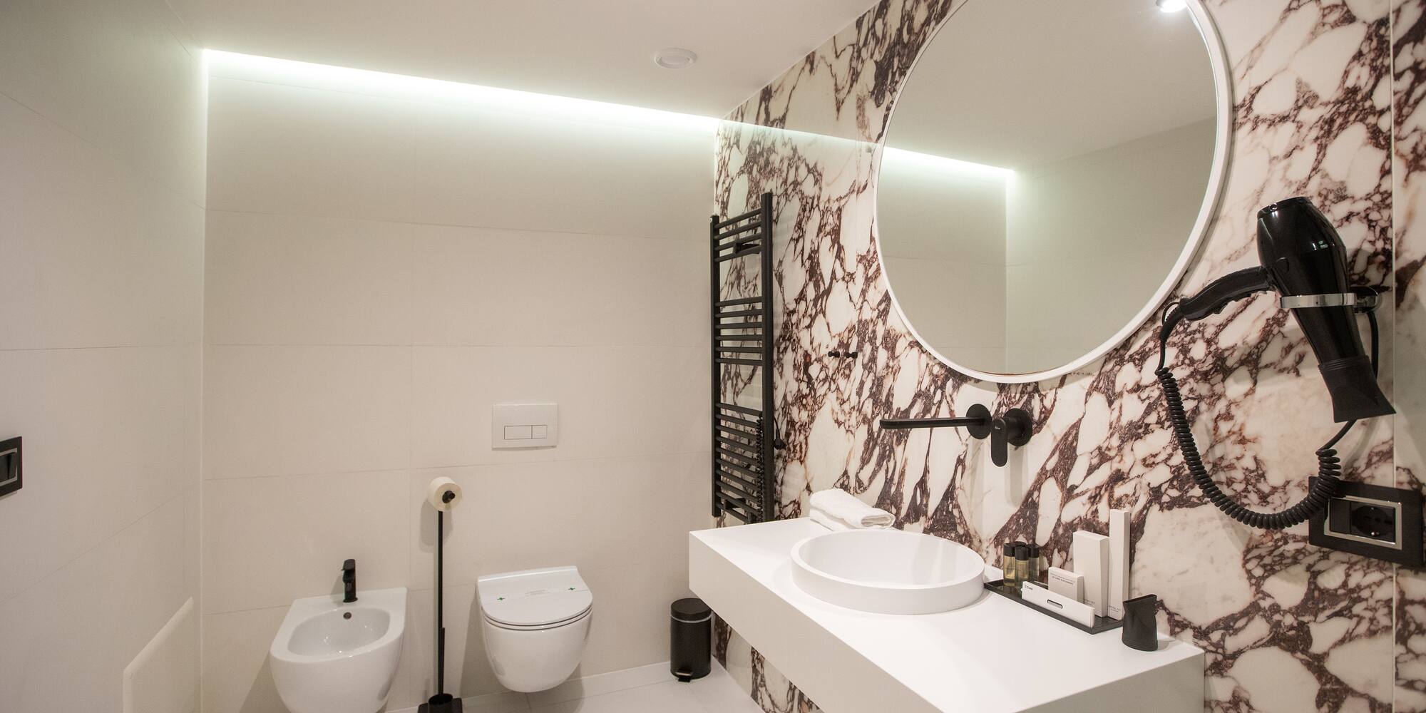 a bathroom with a round mirror and a sink