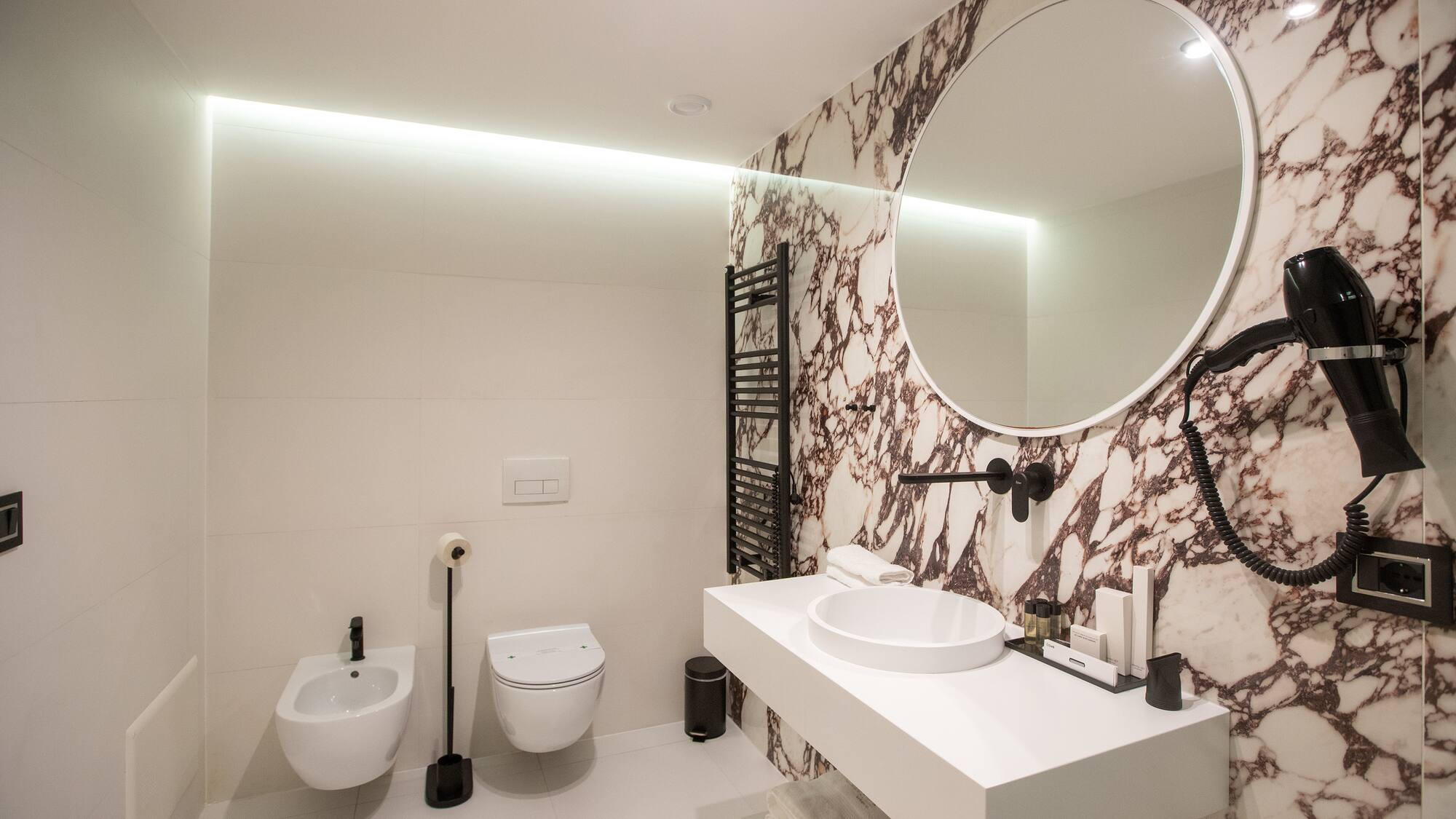 a bathroom with a round mirror and a sink
