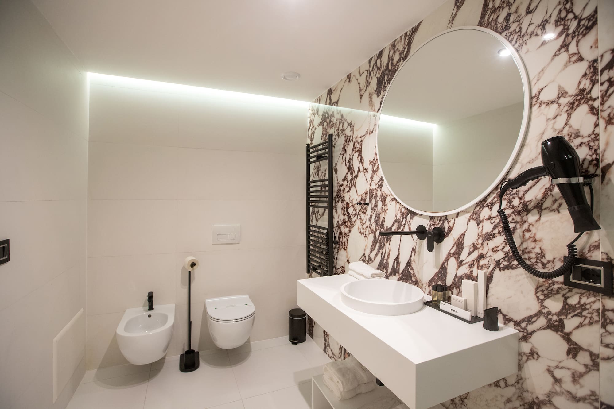 a bathroom with a round mirror and a sink