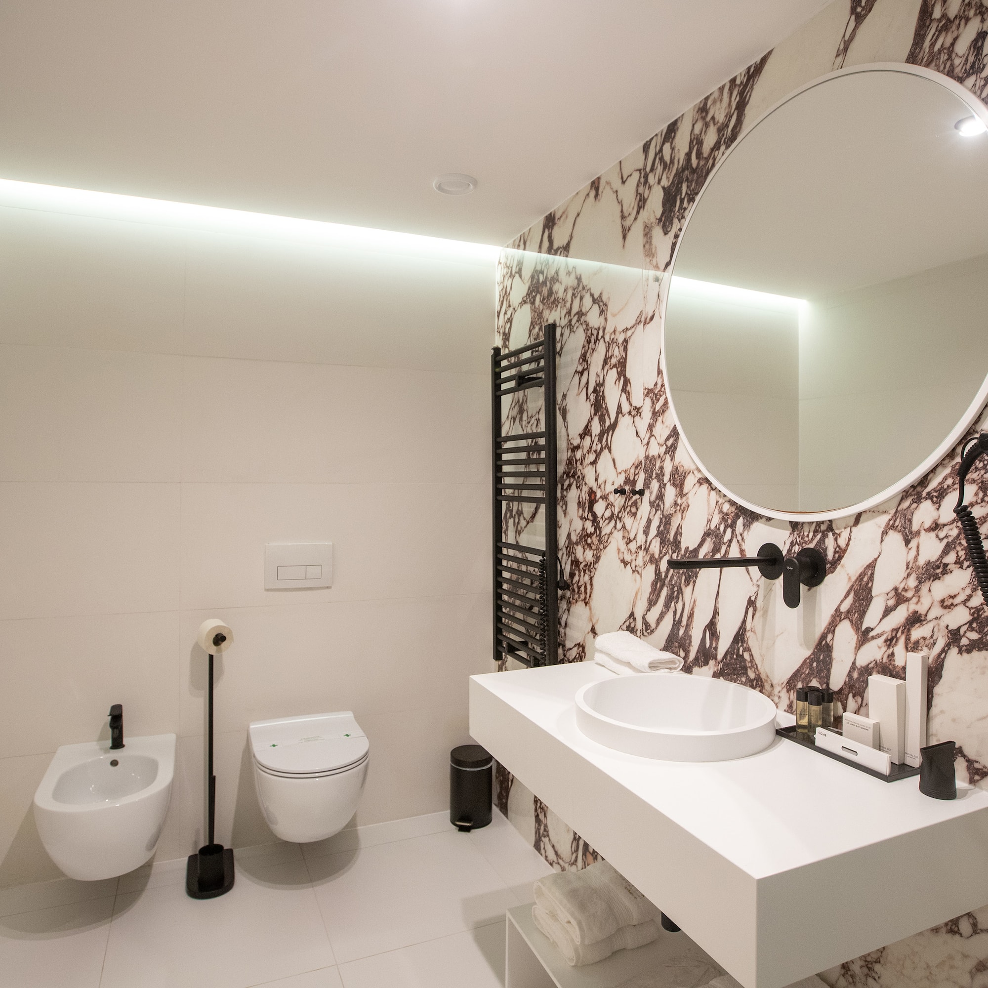 a bathroom with a round mirror and a sink