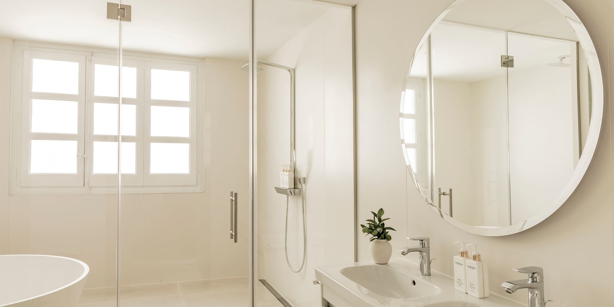 a bathroom with a large round mirror and a sink