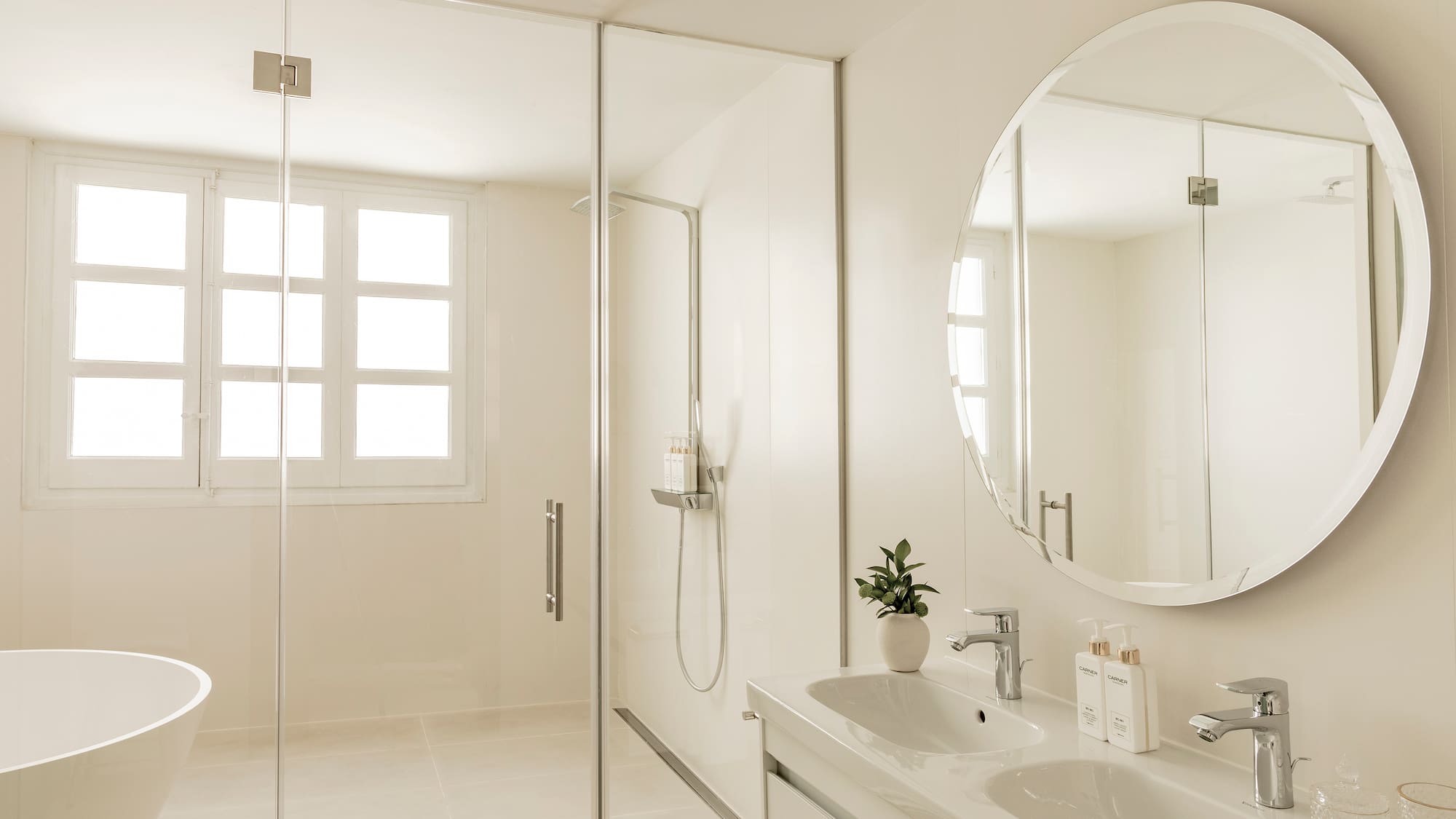 a bathroom with a large round mirror and a sink