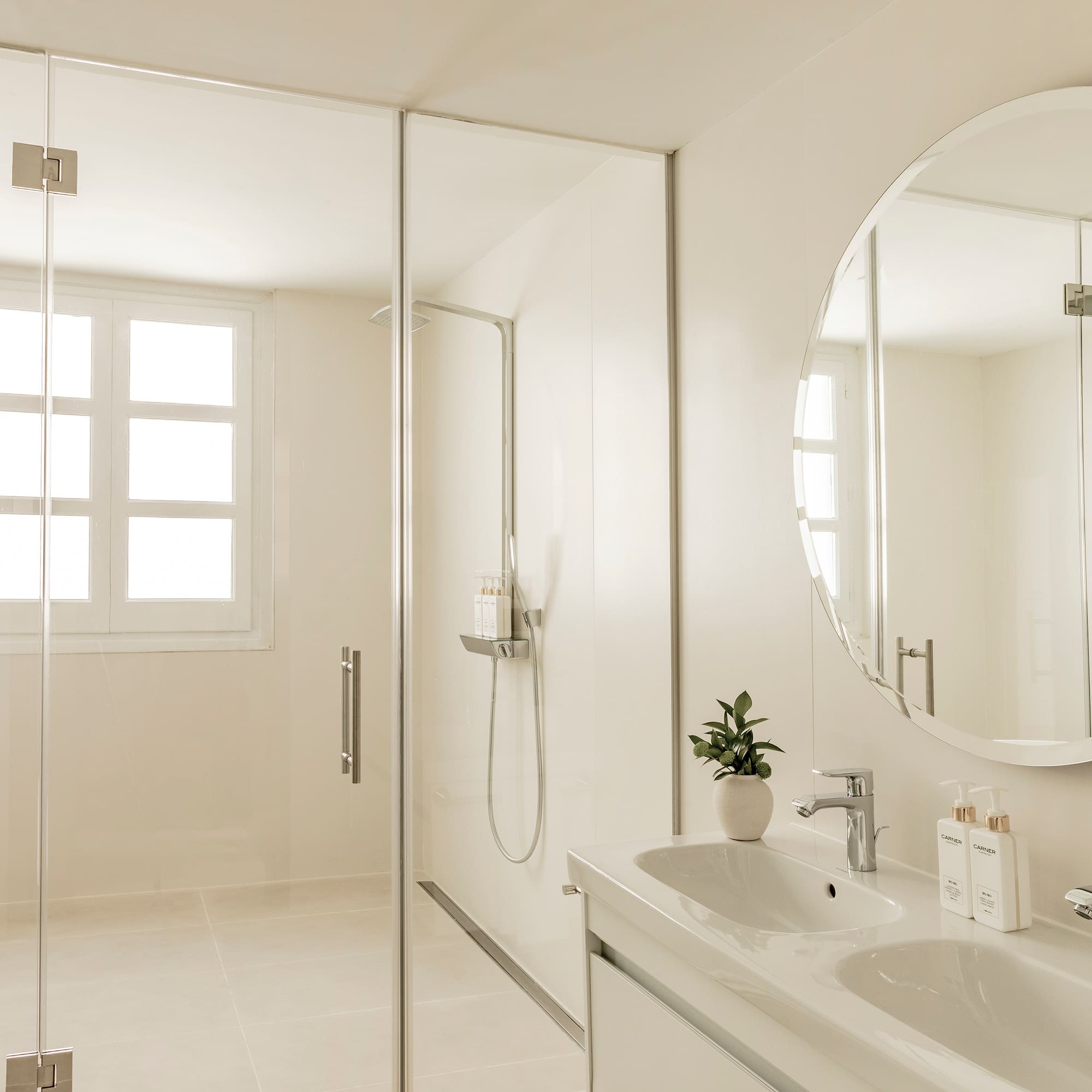 a bathroom with a large round mirror and a sink