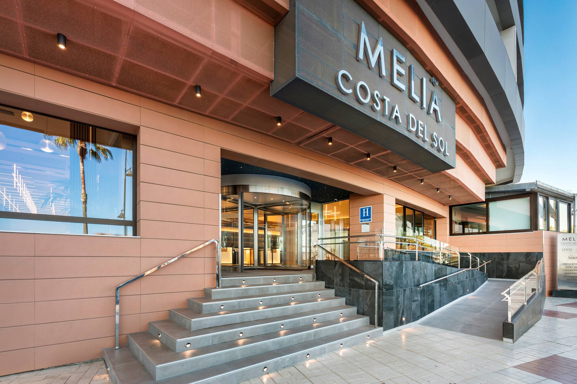 Meliá Costa del Sol hotel: modern entrance, steps, revolving door, ramp.