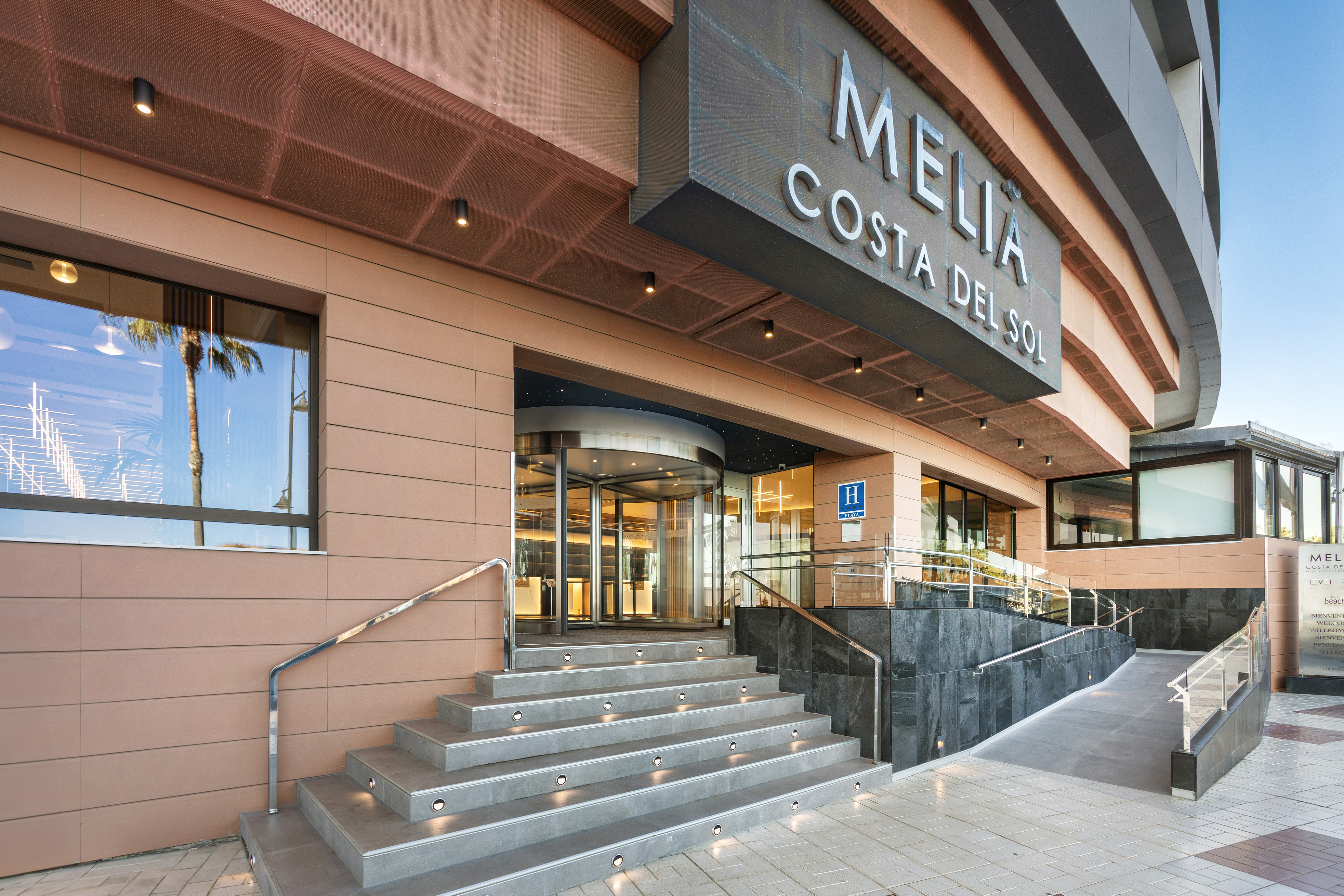 Meliá Costa del Sol hotel: modern entrance, steps, revolving door, ramp.