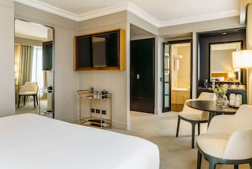 a room with a bed and a table and chairs