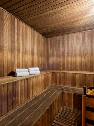 a wooden sauna with a bucket and towels