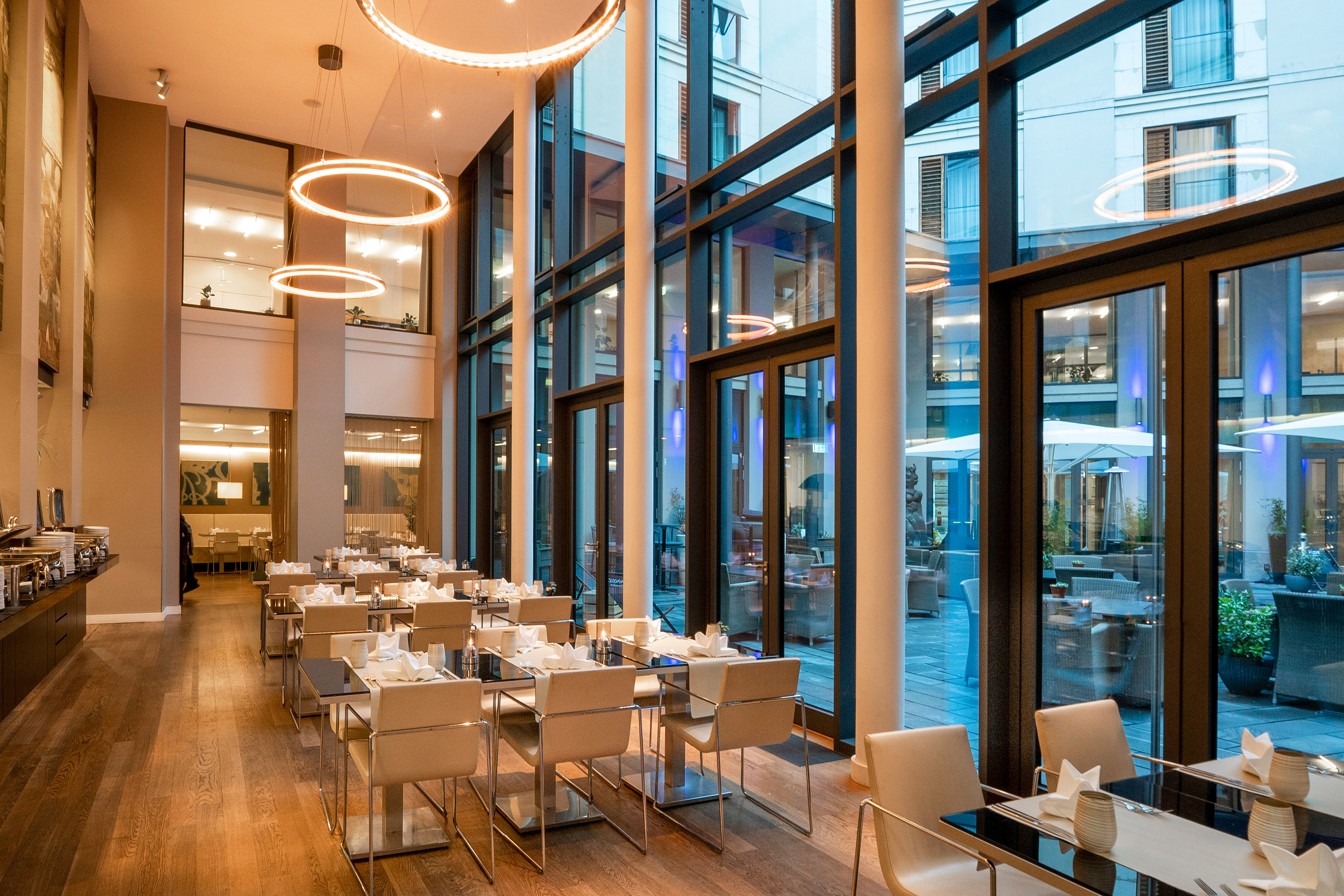 Modern hotel restaurant with set tables, buffet, and large glass windows. - VEN, Bucătărie internațională - Innside Dresda, Dresda