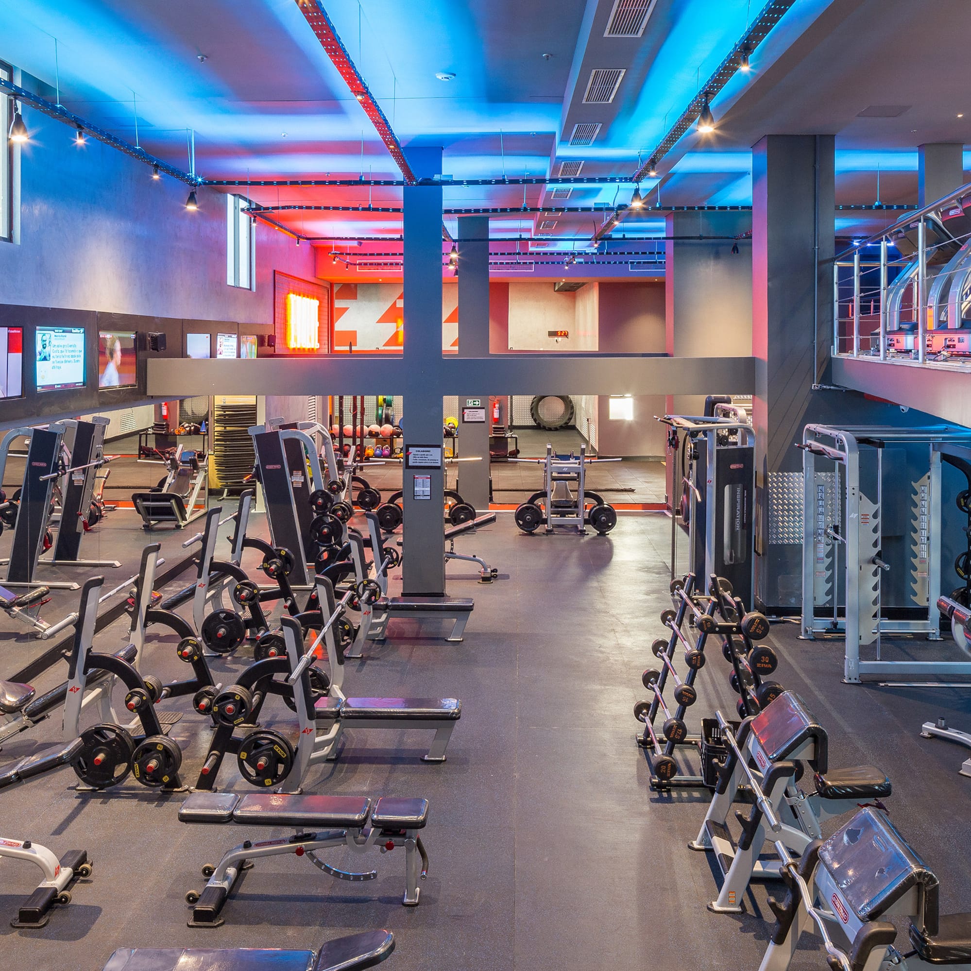 Modern gym with free weights, strength machines, and treadmills.
