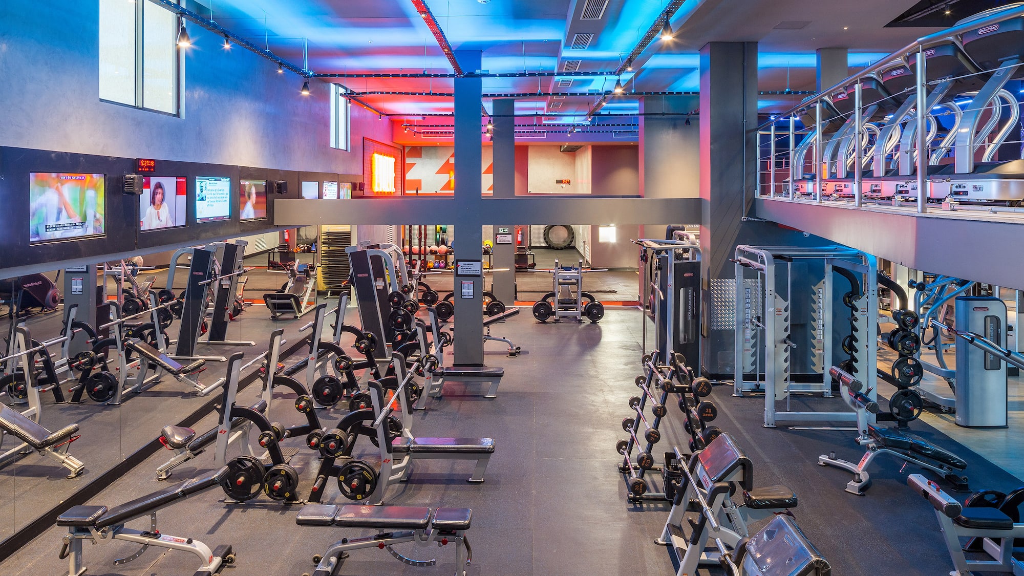 Spacious modern gym with weightlifting equipment, free weights, and treadmills.