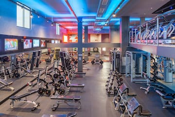 Spacious modern gym with weightlifting equipment, free weights, and treadmills.