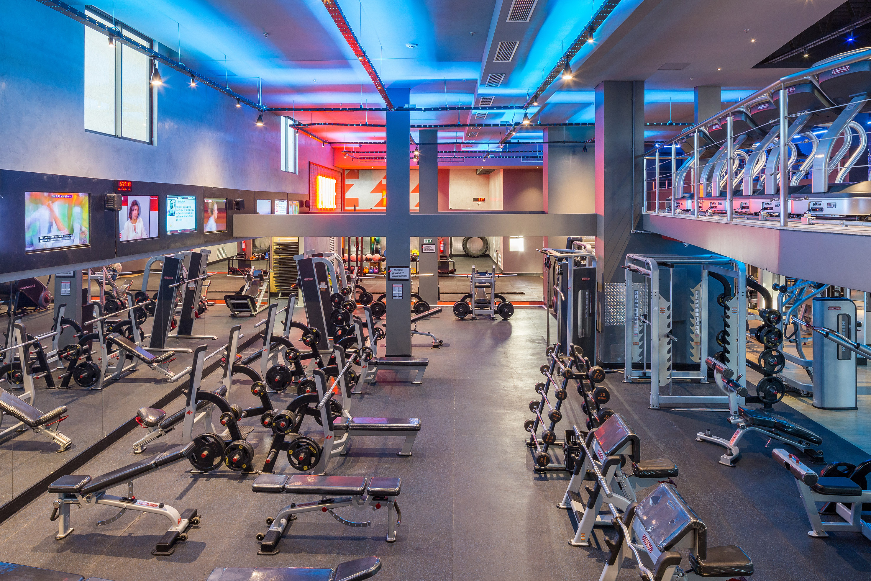 Spacious modern gym with weightlifting equipment, free weights, and treadmills.