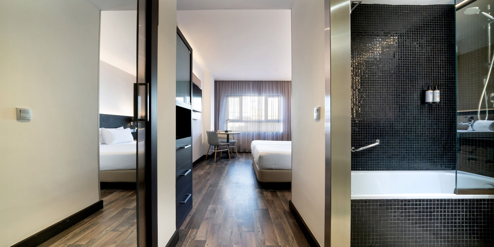 a room with a bathtub and beds